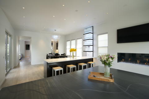 Dining room area with a bar counter in foreground. In-wall invisible speakers show on the ceiling.