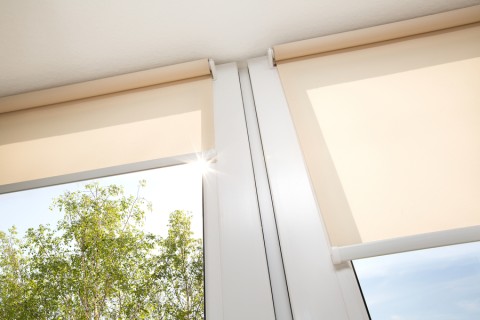 Image is of a pair of motorized shades covering the windows in a home.