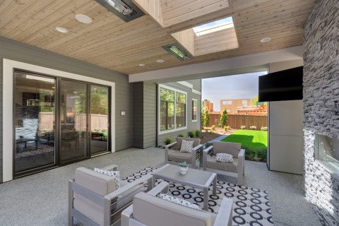 A covered patio with a TV and seating for gatherings