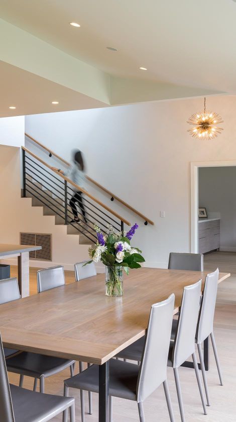 Dining room with beautiful lighting and a woman going upstairs